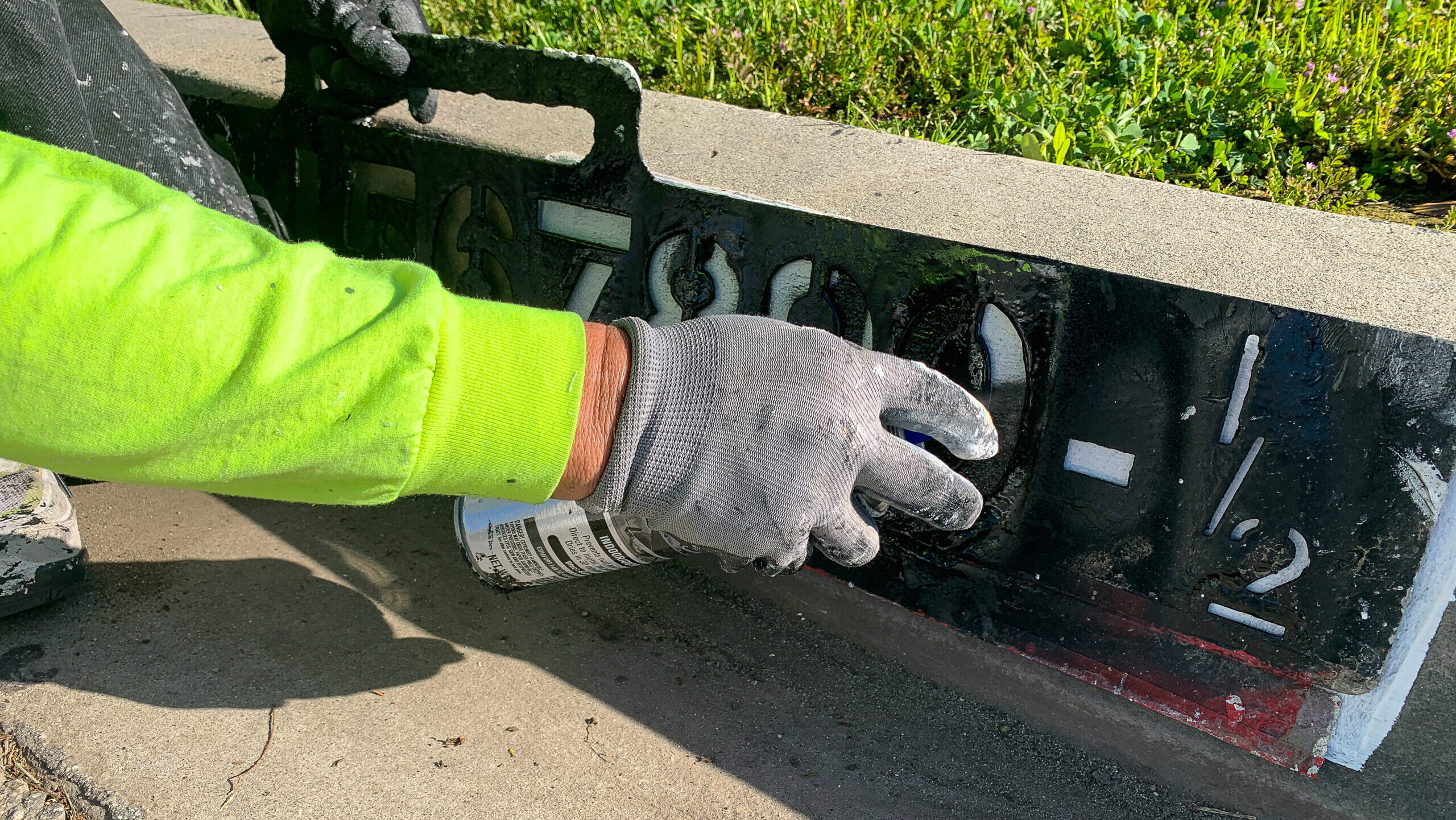 Worker paints address number on curb