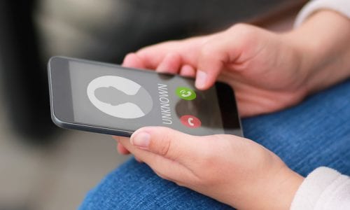 Close up of hands holding phone with unknown caller