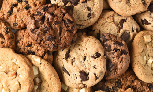 Closeup of a group of assorted cookies. Chocolate chip, oatmeal raisin, white chocolate fill the frame.