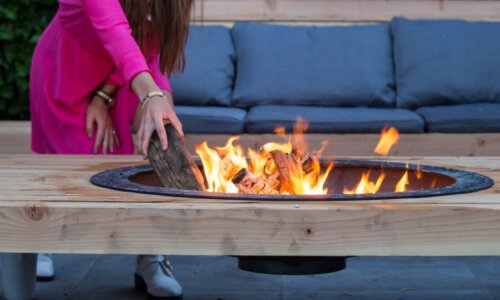woman putting log in firepit