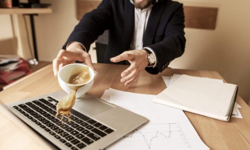 A man spills coffee on his keyboard at work.