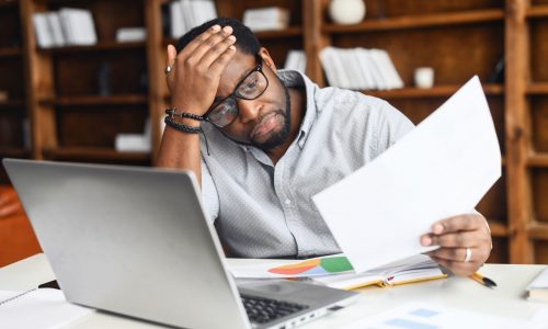 Stressed man looks at paperwork