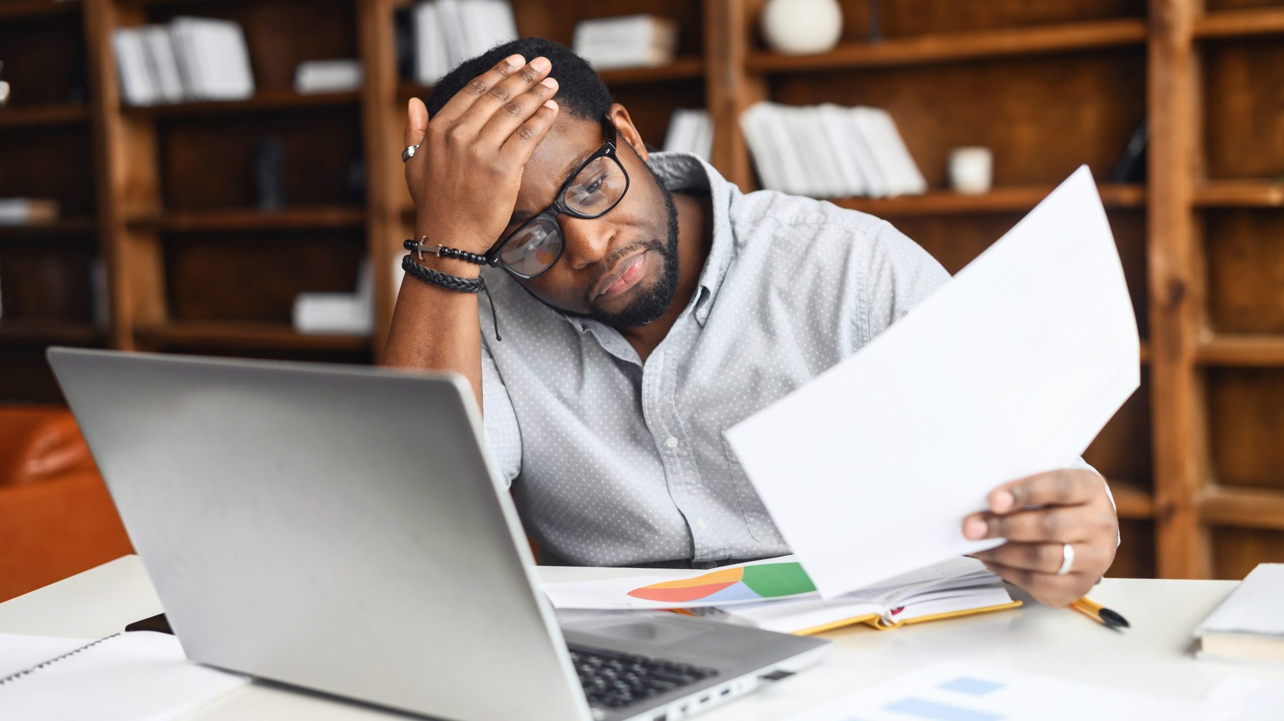 Stressed man looks at paperwork