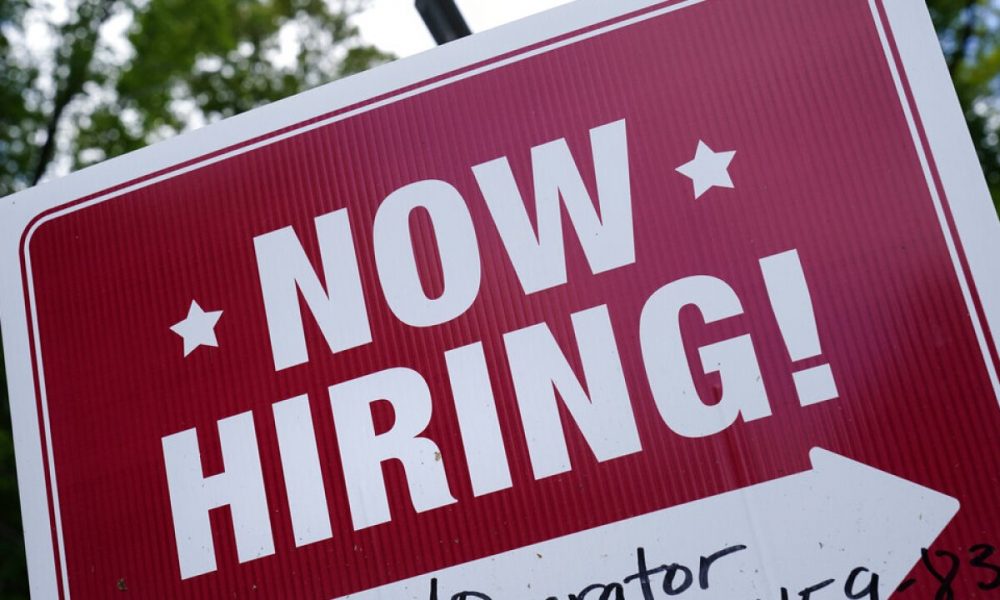 A "now hiring" sign is posted in Garnet Valley, Pa., Monday, May 10, 2021. Applications for unemployment benefits inched down last week, Thursday, April 21, 2022, as the total number of Americans collecting aid fell to its lowest level in more than 50 years. (AP Photo/Matt Rourke, File)