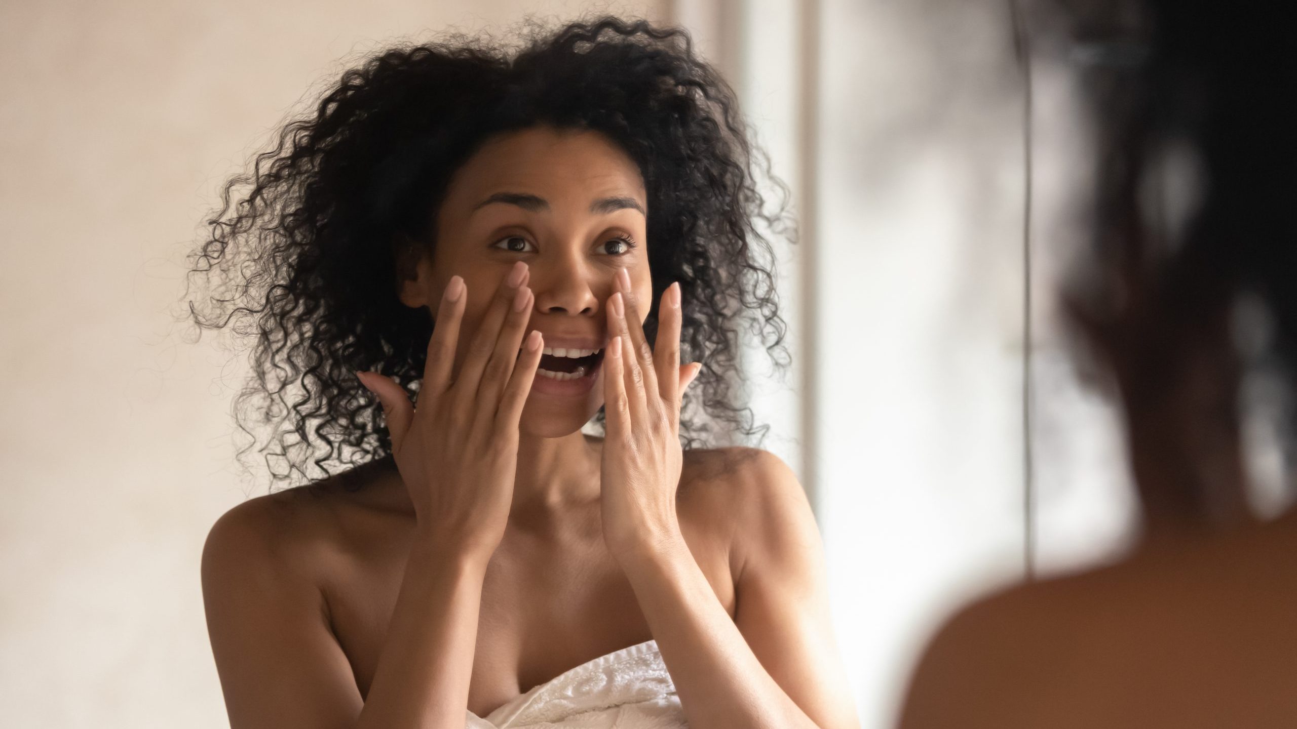 Woman applies moisturizer or BB cream to face