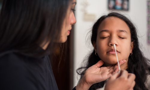 Giving girl nasal swab for COVID rapid test.