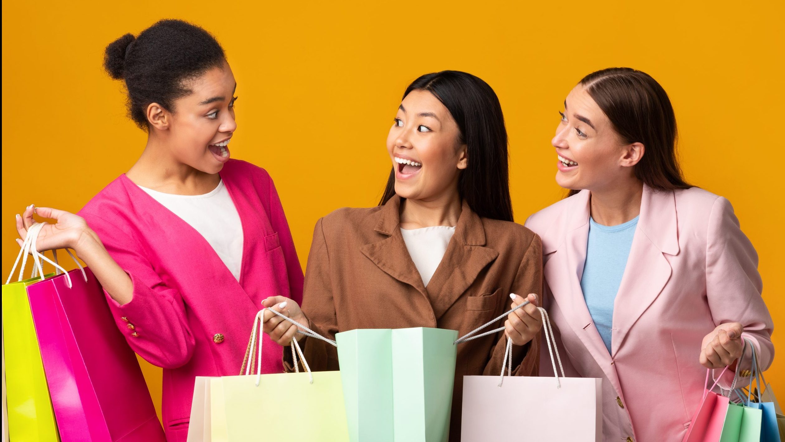 Happy women hold shopping bags