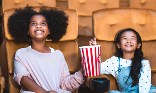 Happy kids watch movie at cinema