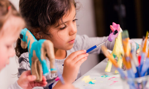 Little girls decorating small paper mache