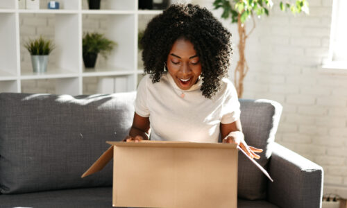 Happy woman opens box with gift or surprise