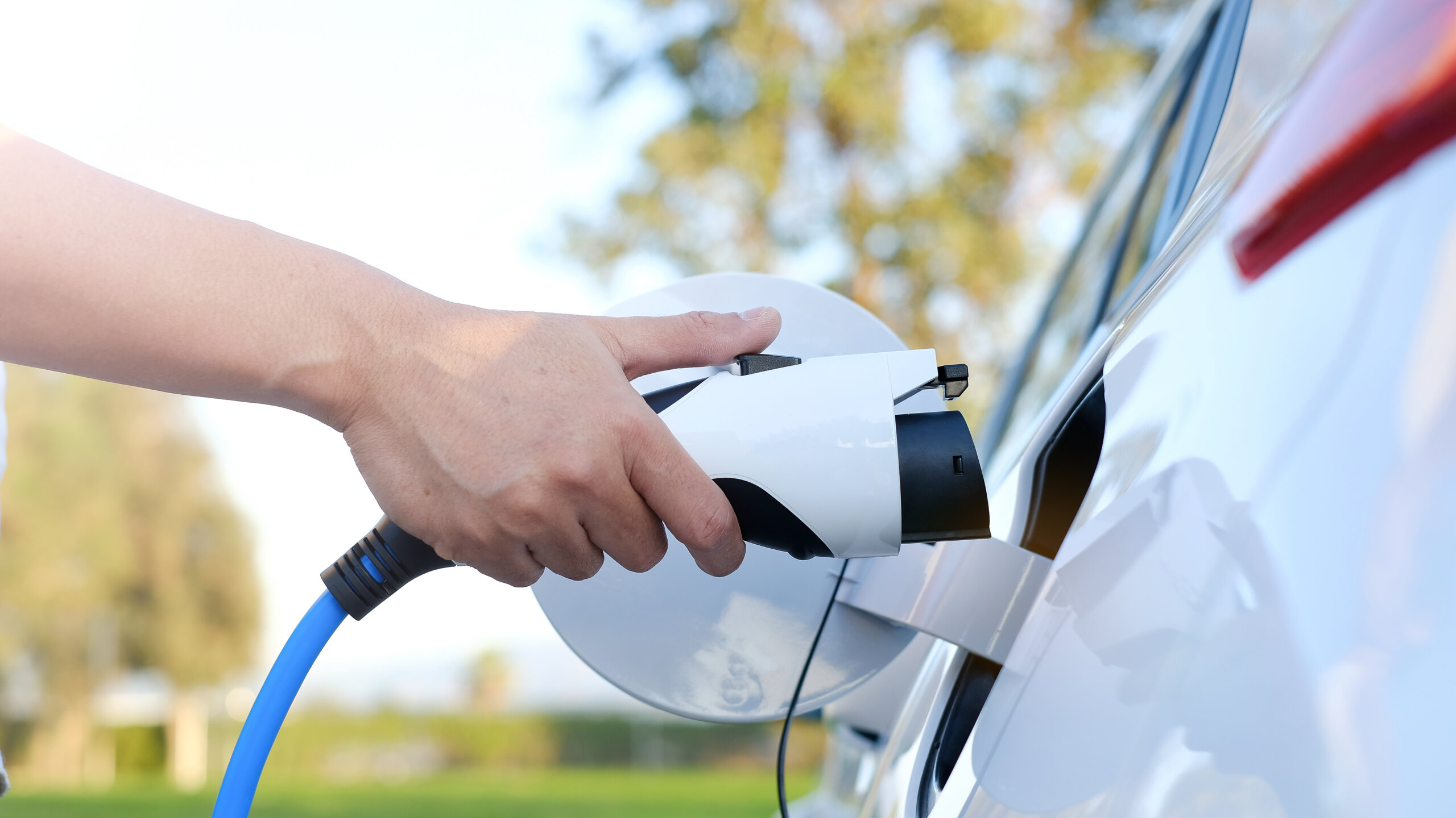 Hand attaches charger to electric car