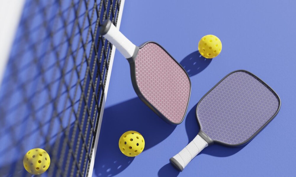 Rackets and balls for playing pickleball at the sports net on the court. 3D rendering