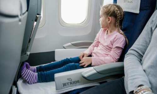 child in JetBox looking out airplane window