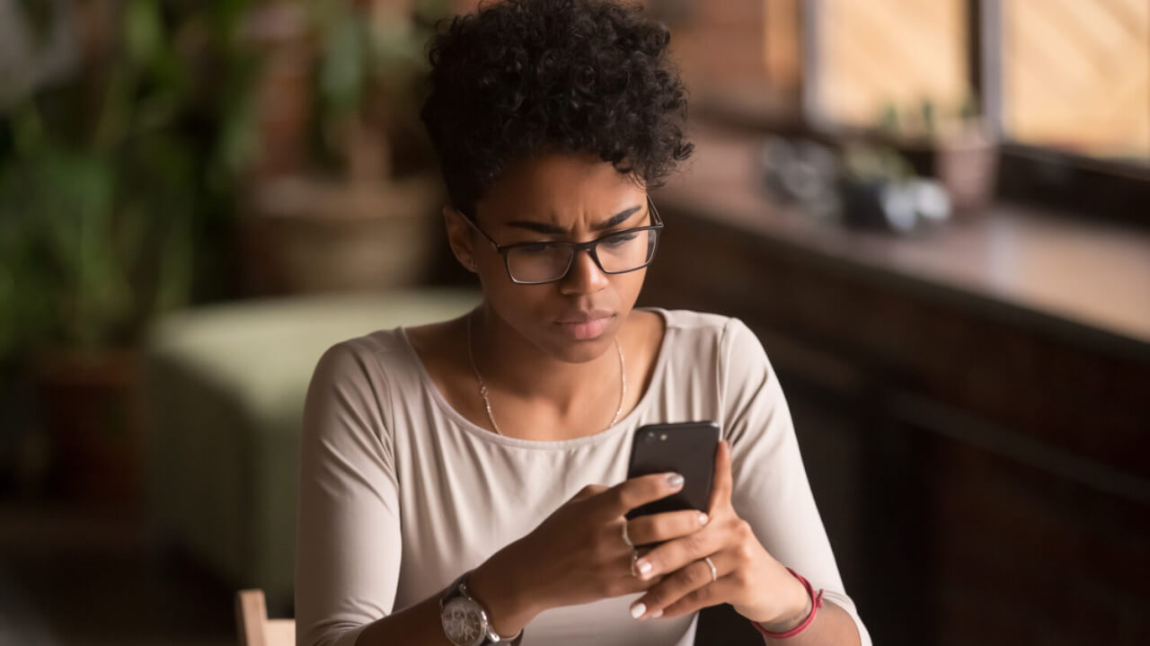 confused or upset woman looks at her phone